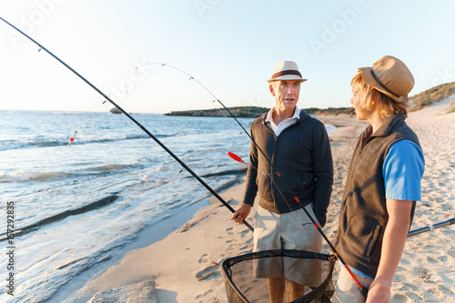 Senior man fishing with his grandson