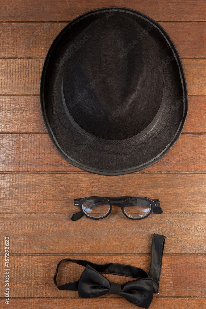 Hat and eyeglasses by bow tie on table Hat and eyeglasses by bow tie on table