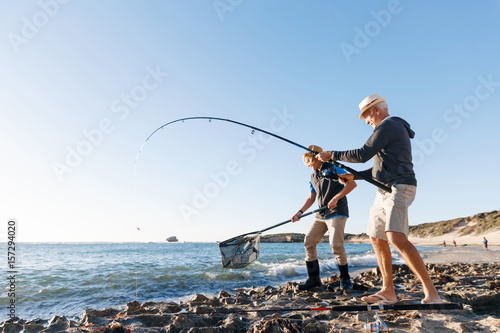 Senior man fishing with his grandson