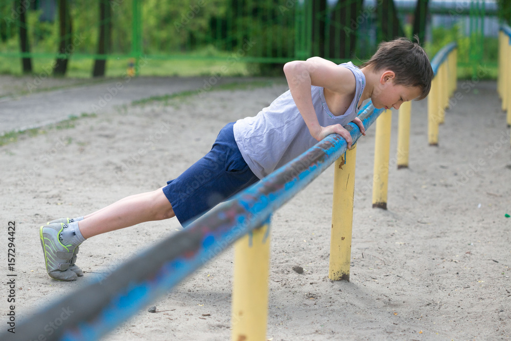 Fototapeta premium Teenager in a T-shirt. Push-up and press