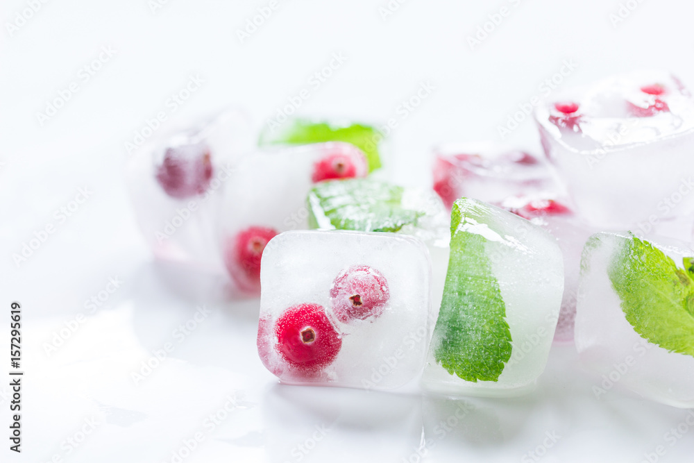 Ice cubes with berries and mint for summer drink on white background Ice cubes with berries and mint for summer drink on white background