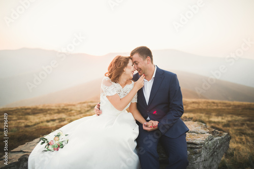 Happy beautiful wedding couple bride and groom at wedding day outdoors on the mountains rock. Happy marriage couple outdoors on nature, soft sunny lights photo