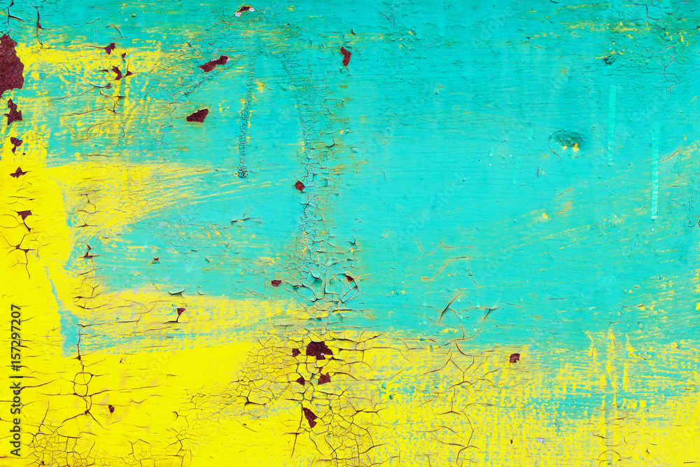 Closeup image of grunge yellow and cyan wall with aged paint as an abstract background.