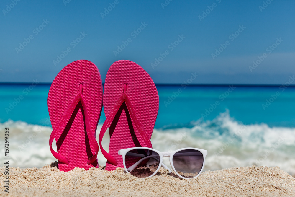 Flip flops with sunglasses on the sandy ocean beach , tropical vacation  concept Stock-Foto | Adobe Stock