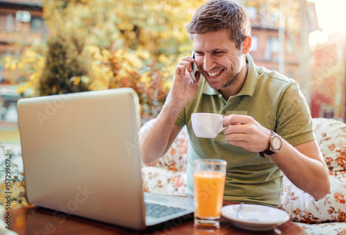 Young man sitting in the cafe and working with laptop. Lifestyle, technology concept © bobex73