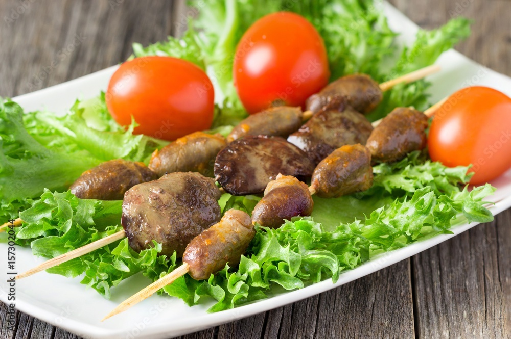 Barbecue  chicken hearts and  liver  with tomato and salad.