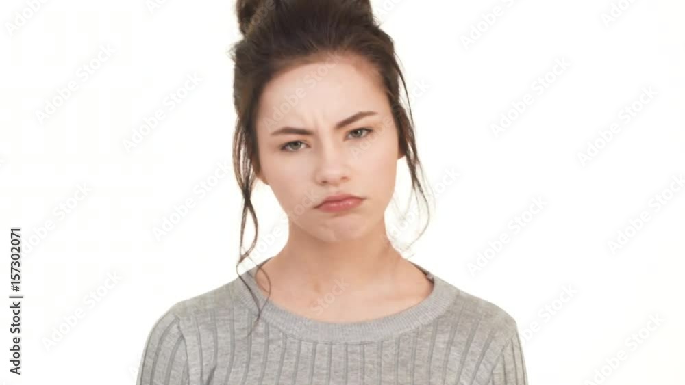 Tired upset Caucasian brunette girl standing on white background and heavily sighing Tired upset Caucasian brunette girl standing on white background and heavily sighing
