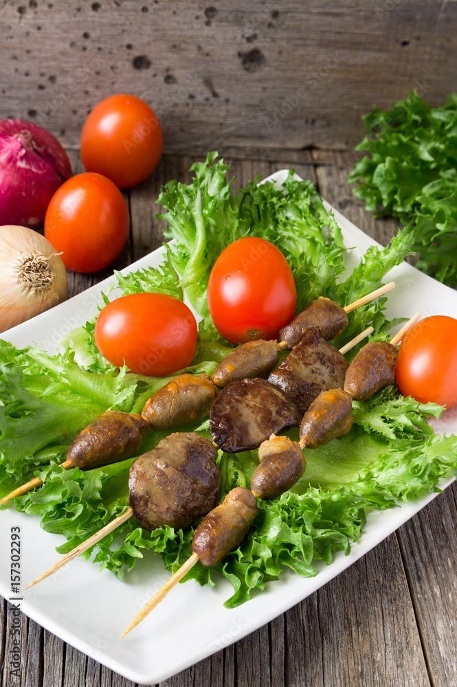 Barbecue chicken hearts and liver with tomato and salad. Barbecue chicken hearts and liver with tomato and salad.