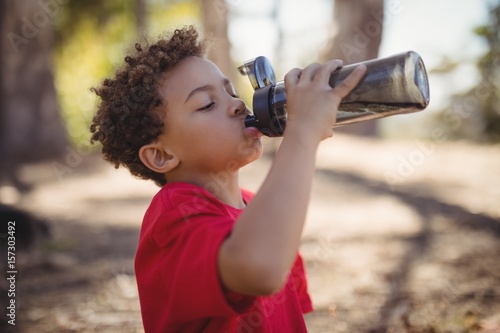 Boy drinking water after workout during obstacle course