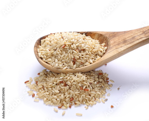 Integral, brown rice and wooden spoon isolated on white background