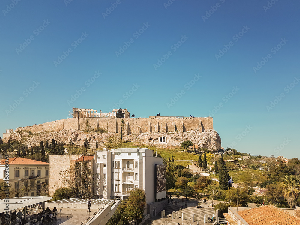 People enjoying their coffee with the view of ancient Greek Acropolis of Athens.
