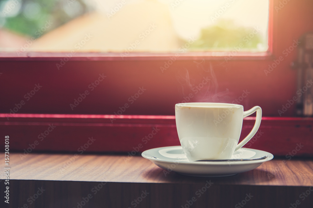 single white cup of espresso hot coffee with morning sun light from windows background on wooden glass table in coffeeshop. single white cup of espresso hot coffee with morning sun light from windows background on wooden glass table in coffeeshop.