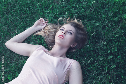 Young woman lying down on grass