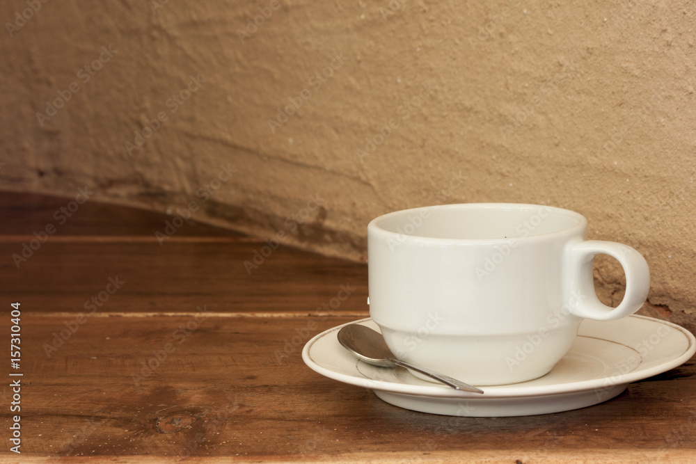 Cup on wood with cement wall.