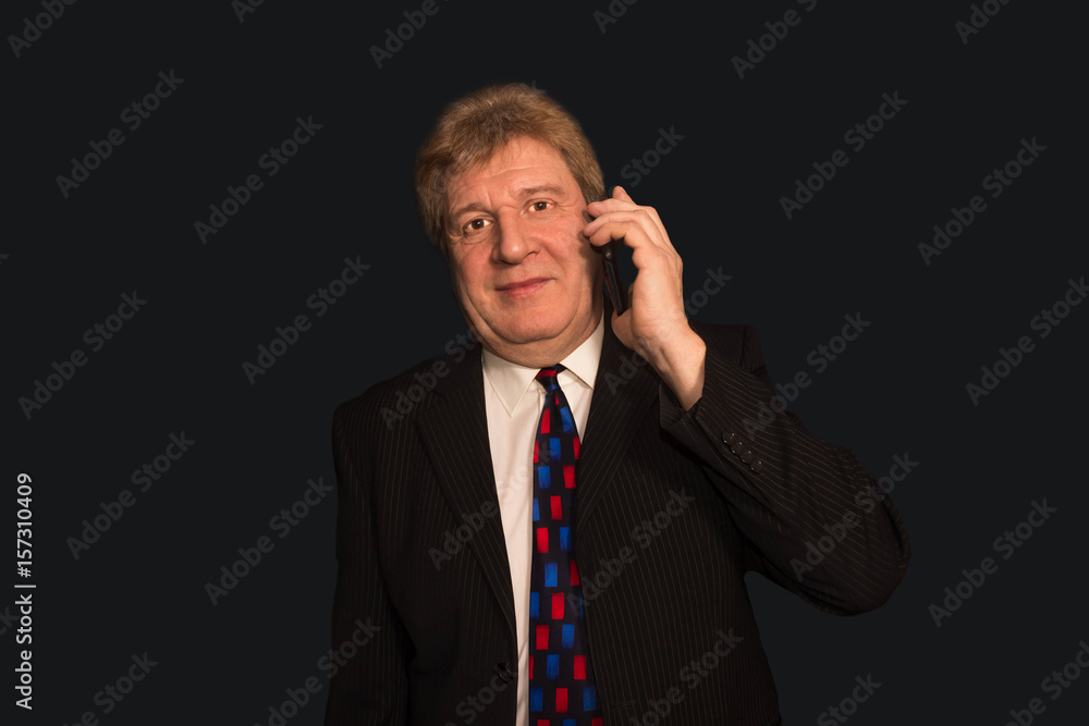 The good news. mature man in suit with mobile phone The good news. mature man in suit with mobile phone