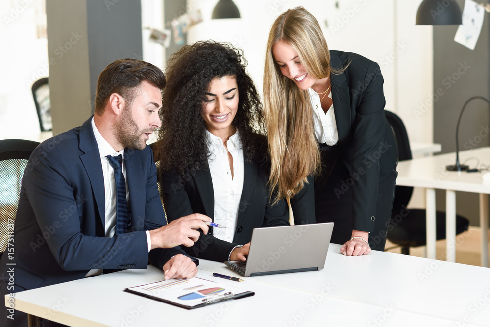 Multi-ethnic group of three businesspeople meeting in a modern office. Multi-ethnic group of three businesspeople meeting in a modern office.