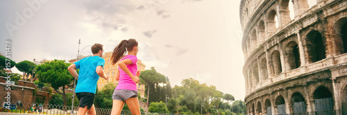Runners running next to colosseum in Rome city, Italy, Europe travel destination. Healthy active people lifestyle. Banner panorama crop.