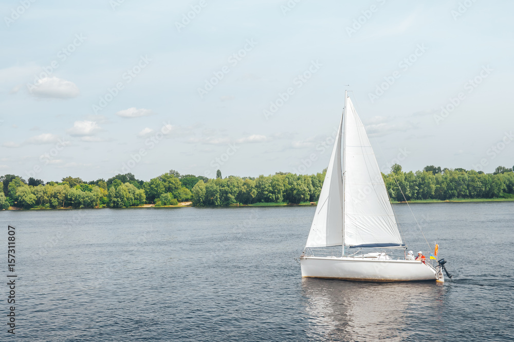 Obraz premium white yacht sailing on a large river