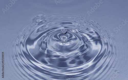 Blue water drop falling down. Blue water splash.