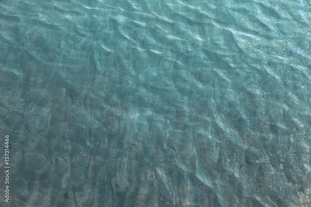 Texture blue sea water with sunny reflections