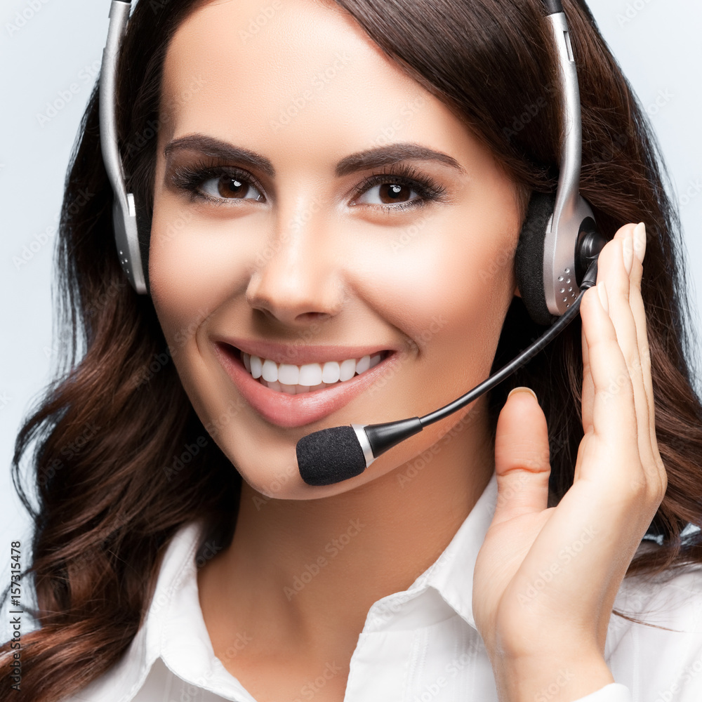 Portrait of happy smiling customer support female phone operator in headset Portrait of happy smiling customer support female phone operator in headset