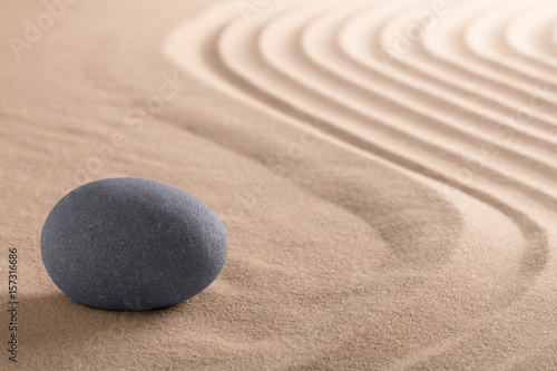 Zen meditation stone garden with rock on raked sand