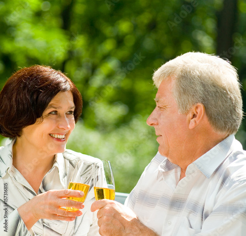 Senior couple celebrating with champagne, outdoors