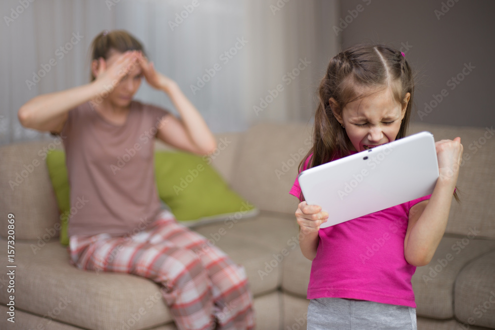 Mother frustrating that her daughter playing video games. Mother frustrating that her daughter playing video games.