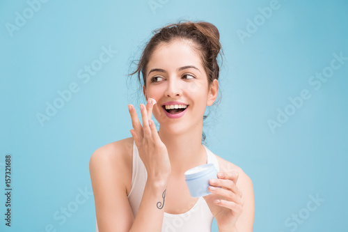 Woman with cream on blue background