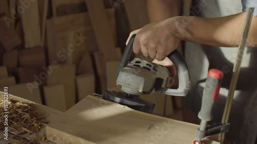 close up hands of woodworker carpenter using brashing scribing machine photo