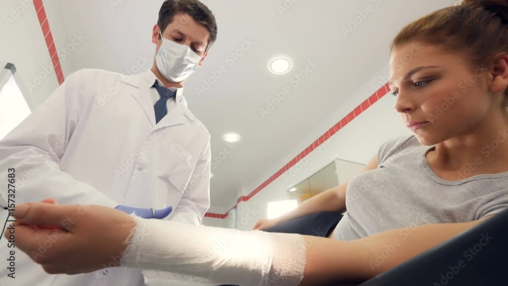 A professional doctor is putting a bandage on a girl's arm A professional doctor is putting a bandage on a girl's arm