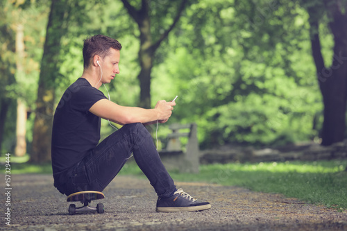 Skateboarder listening music from smartphone