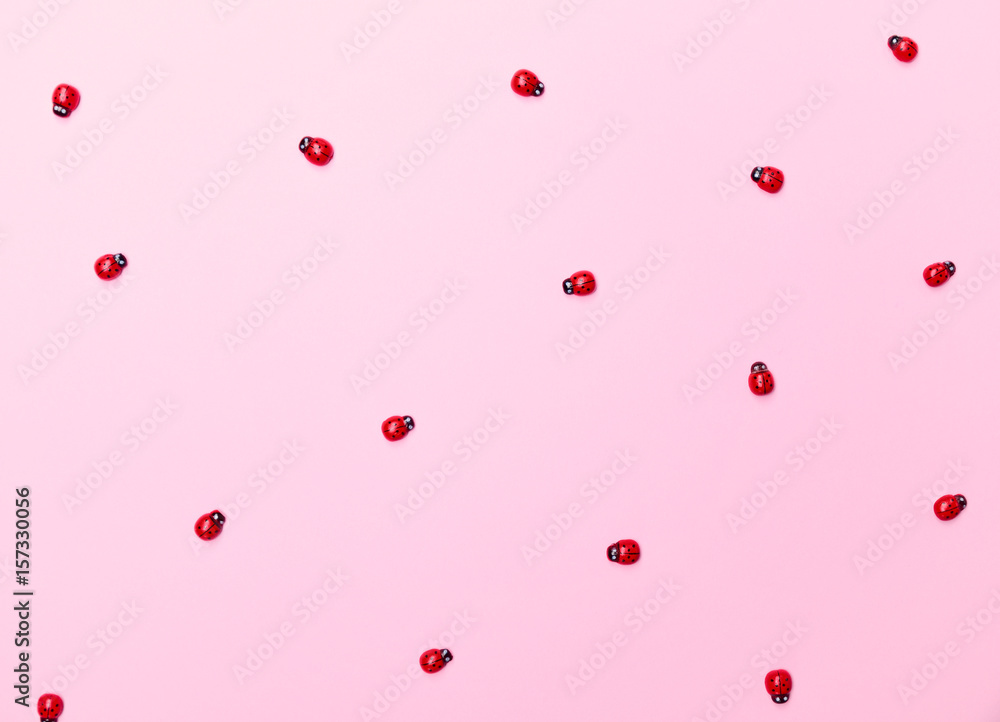 Decorative wooden ladybugs on a pink surface