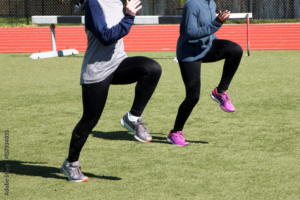 Two girls doing A-Skips sprint drills on a turf field Stock Photo ...