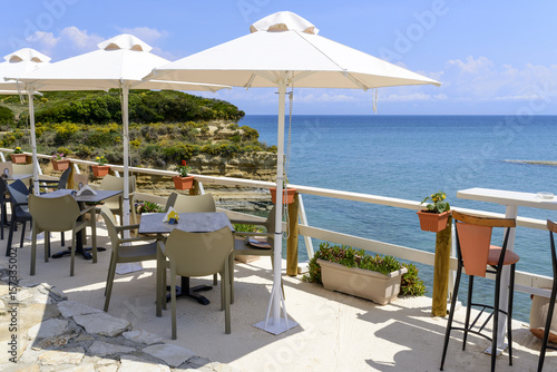 Restaurant furniture with umbrella with magnificent view of the cliffs near Sidari - Corfu island in Greece.