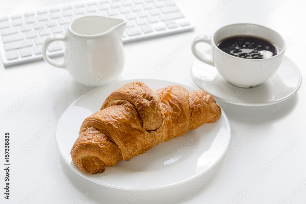 croissant and cup of coffee on office desk for business breakfast white background croissant and cup of coffee on office desk for business breakfast white background