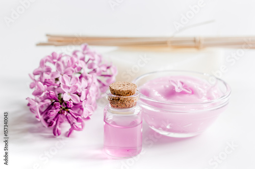 take bath with lilac cosmetic set and blossom on white table background