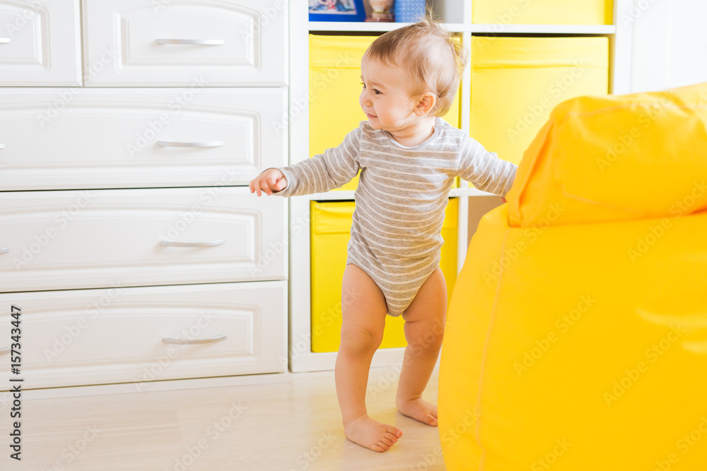 Cute happy laughing baby boy playing on white bedroom. Cute happy laughing baby boy playing on white bedroom.