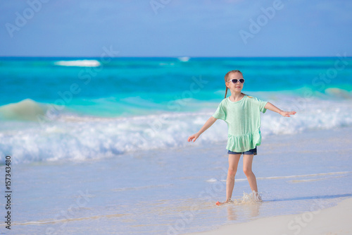 Cute little girl walking at beach during caribbean vacation