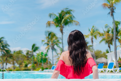Beautiful young woman relaxing in swimming pool. Happy girl in outdoor pool at luxury hotel © travnikovstudio