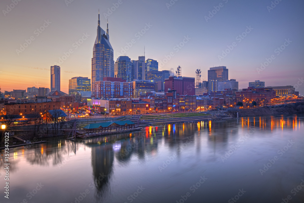 Skyline of Nashville, Tennessee at sunset showing reflections in the Cumberland River