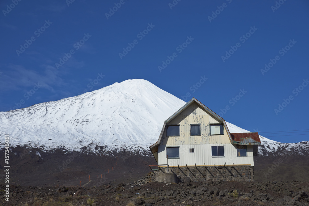 Snow capped peak of Antuco Volcano (2,979 metres) rising above the small ski resort in Laguna de Laja National Park in the Bio Bio region of Chile.
