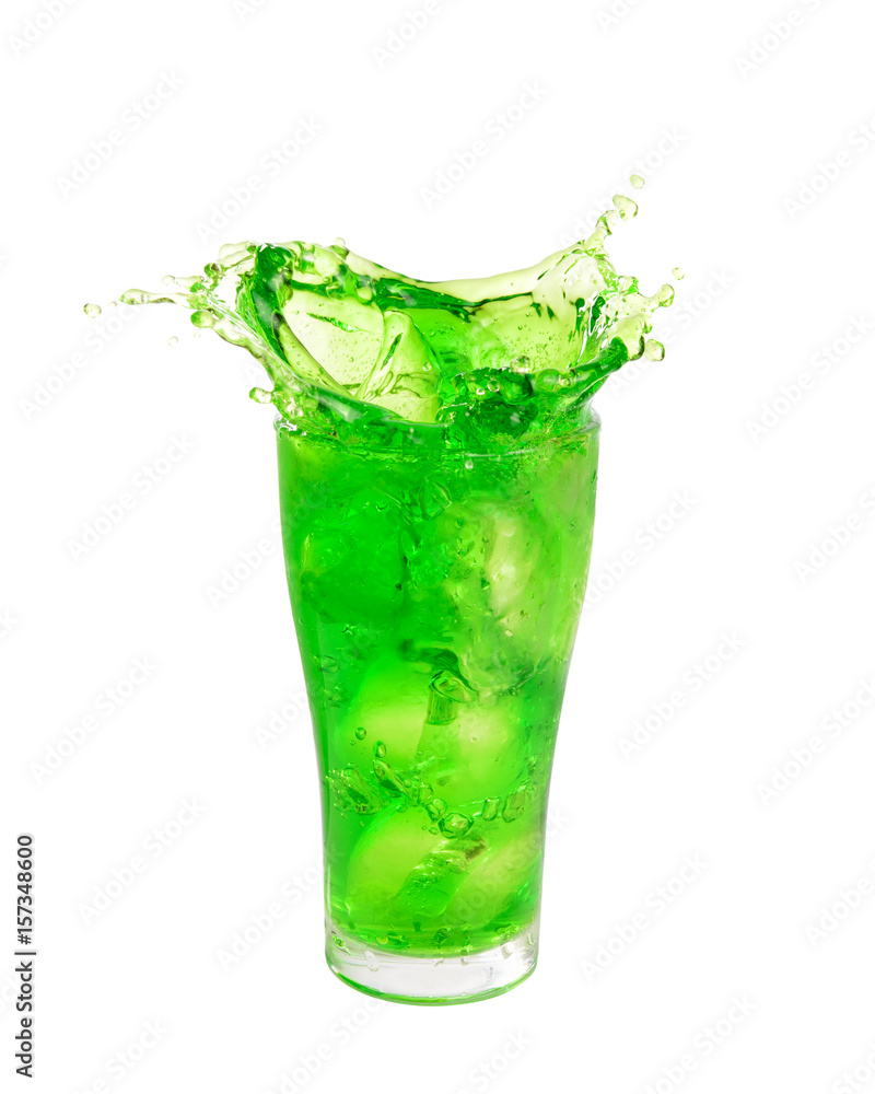 Green soft drink splashing out of glass isolated on white background. Green soft drink splashing out of glass isolated on white background.