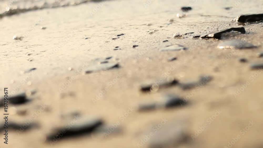 Locked down shot of waves rolling up a sandy beach Locked down shot of waves rolling up a sandy beach
