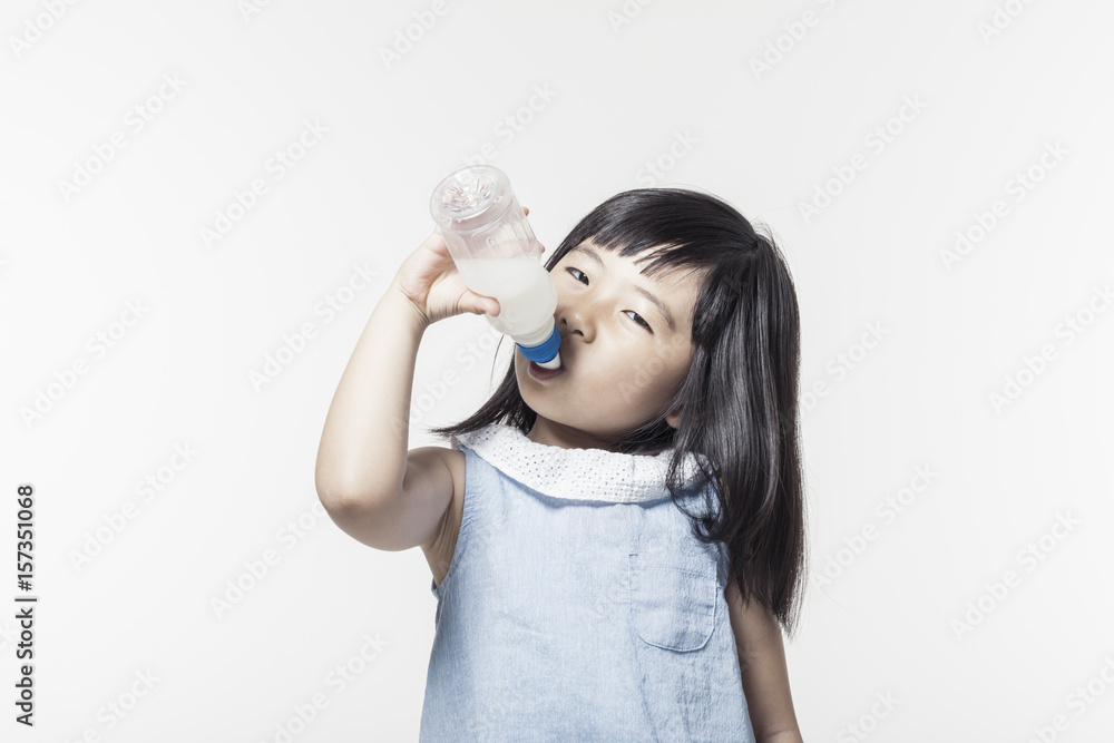 A little girl portrait with smile drinking a drinking water isolated white. A little girl portrait with smile drinking a drinking water isolated white.