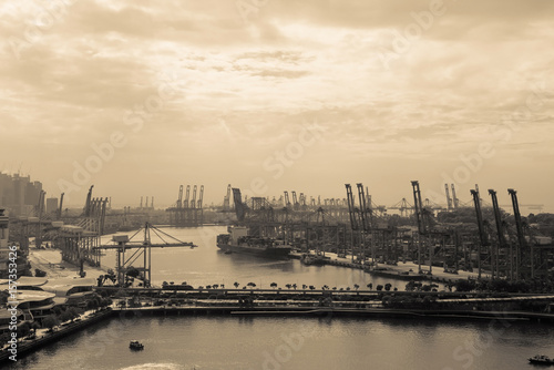 Container Cargo freight ship with working crane bridge in shipyard