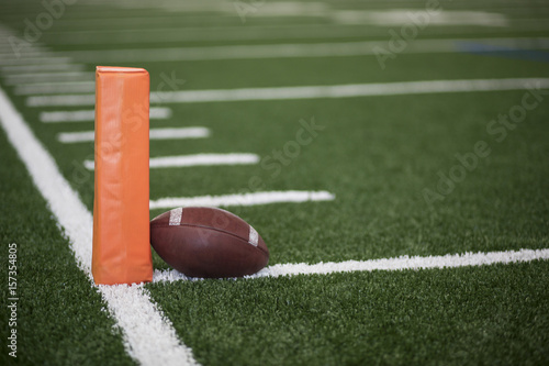 Vászonkép Ball resting on the goal line of a Football field endzone next to an orange pylo