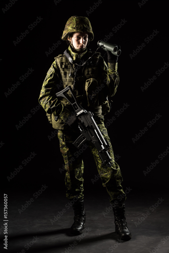 Portrait of armed woman with camouflage. Young female soldier observe with binoculars. Child soldier with gun in war, hause ruins background. Military, army people concept Portrait of armed woman with camouflage. Young female soldier observe with binoculars. Child soldier with gun in war, hause ruins background. Military, army people concept
