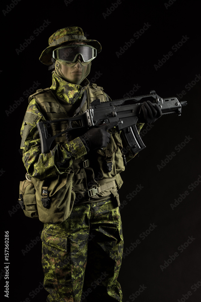 Portrait of armed woman with camouflage. Young female airsoft sniper observe with firearm. Soldier with gun in war, black background. Military, army people concept Portrait of armed woman with camouflage. Young female airsoft sniper observe with firearm. Soldier with gun in war, black background. Military, army people concept