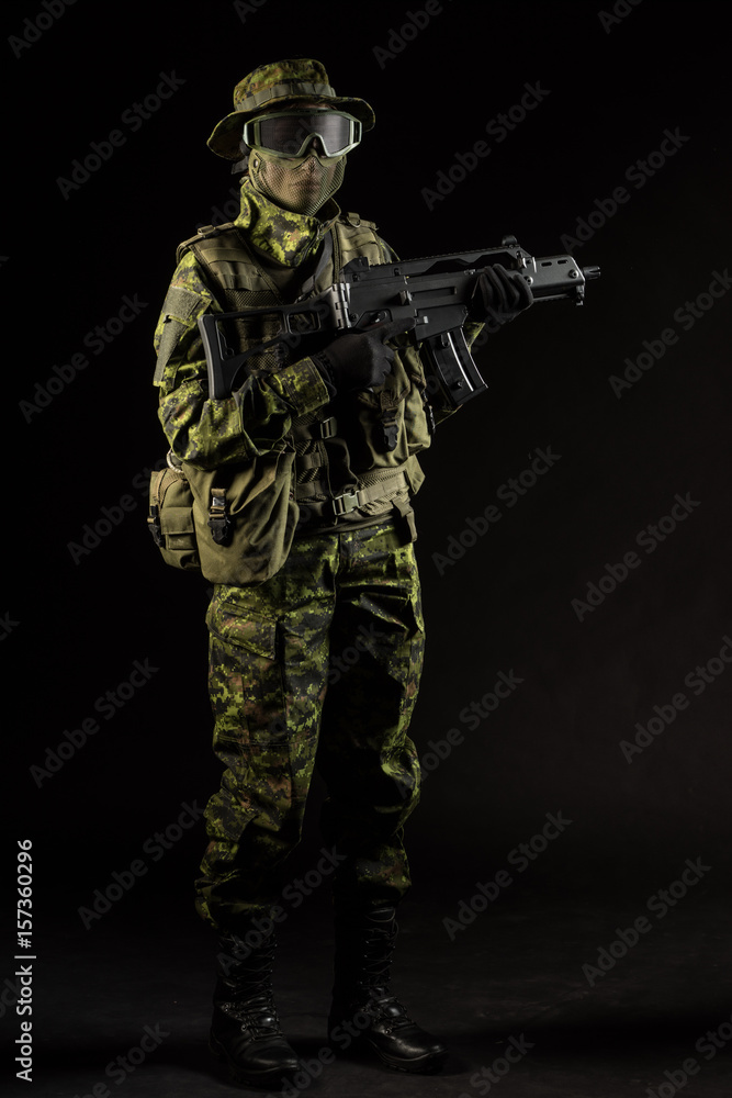 Portrait of armed woman with camouflage. Young female airsoft sniper observe with firearm. Soldier with gun in war, black background. Military, army people concept Portrait of armed woman with camouflage. Young female airsoft sniper observe with firearm. Soldier with gun in war, black background. Military, army people concept